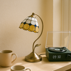 Vintage Tiffany-inspired lamp with curved stand, warm golden glow for cosy rooms