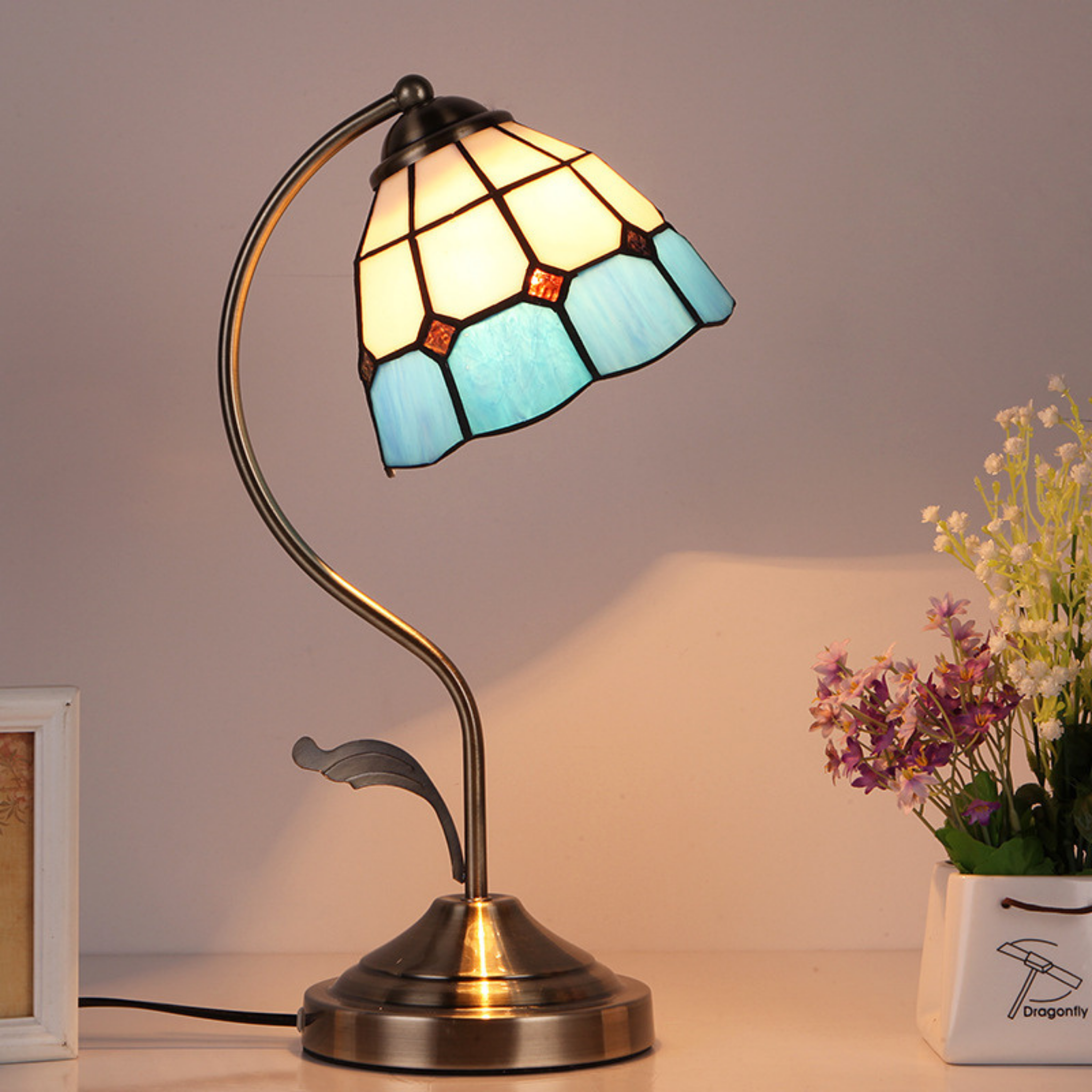 Art Deco Tiffany-style table lamp with bronze curved stand and stained glass shade in white and blue tones, vintage-inspired lighting ideal for bedrooms, desks, or cosy reading spaces