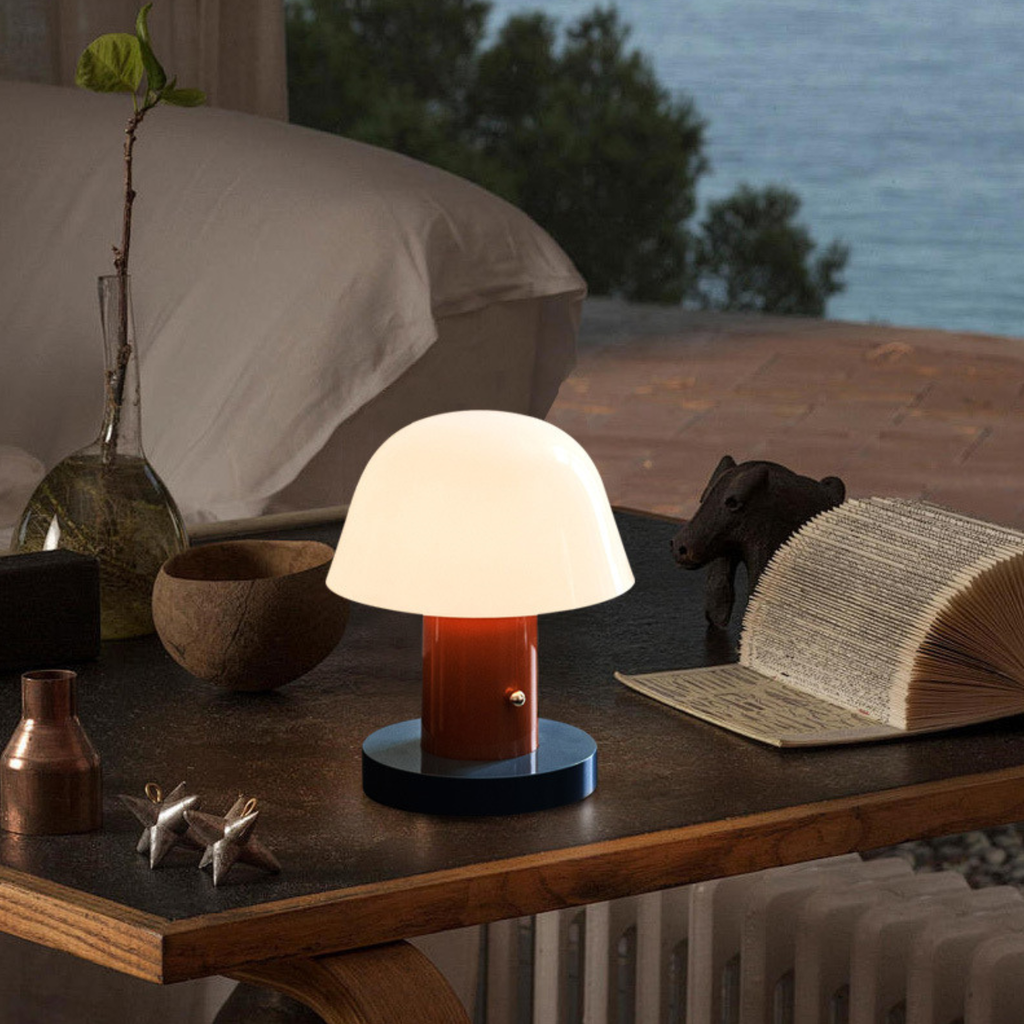 Table lamp on a wooden surface with a scenic background