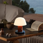 Table lamp on a wooden surface with a scenic background