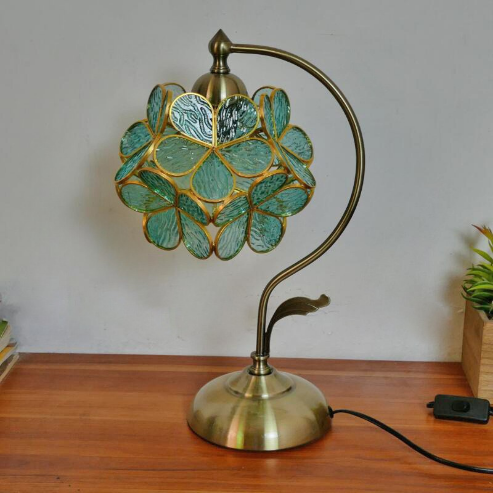 Close-up of Aqua Petal Glow Lamp — artisan stained glass shade in aqua tones with brass curved arm, perfect for bedside or reading corner styling