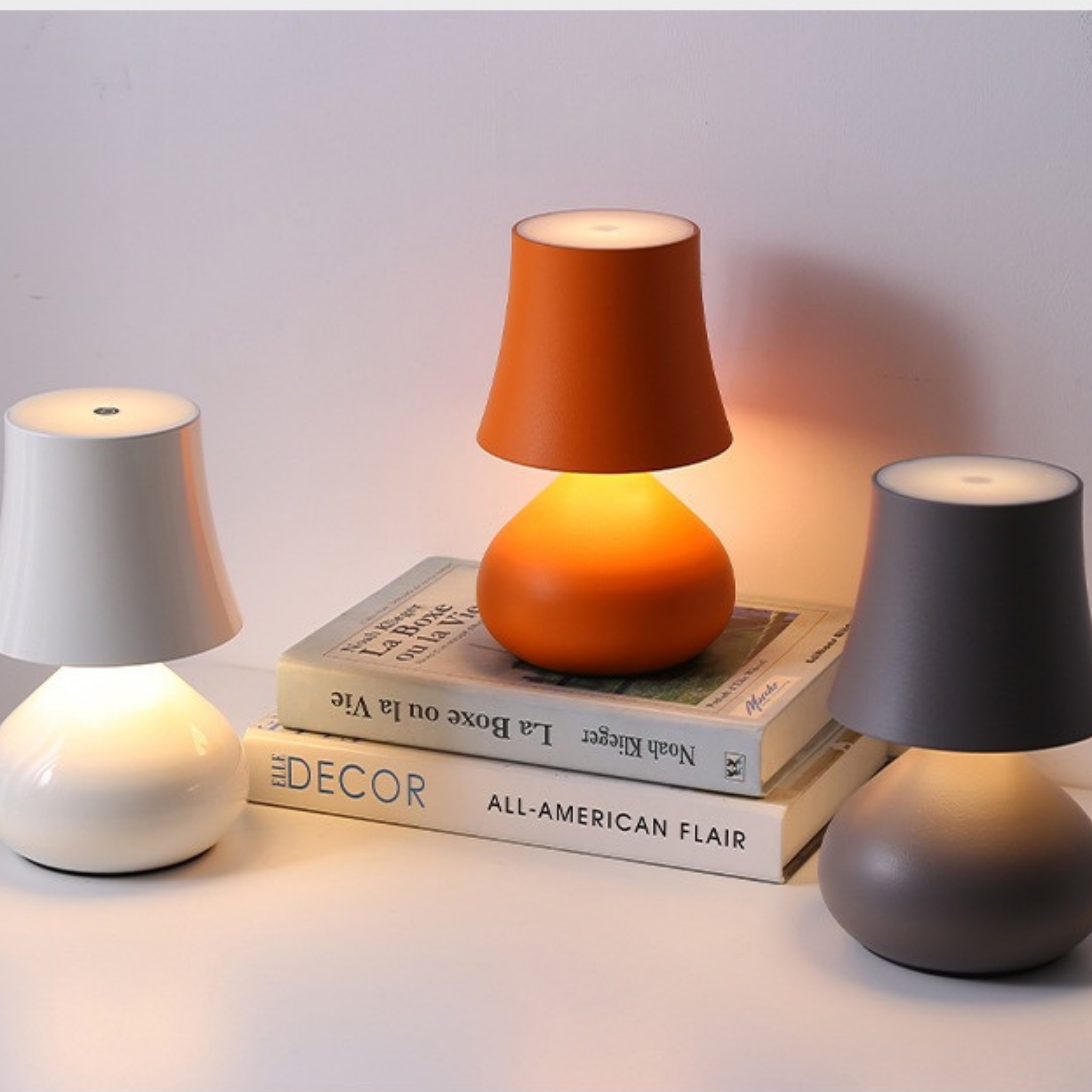 Clementine Glow Lamps in White, Orange, and Grey arranged on books — modern bedside lighting for Scandinavian and contemporary homes, KaShi Living
