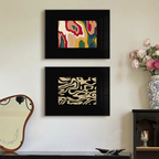 Two framed abstract artworks on a wall with decorative items below.