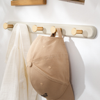 A warm cream-effect wall hook rack with gold-tone pegs for coats, bags, keys and everyday hallway organisation.