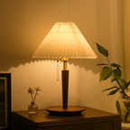 The Arden Pleat Table Lamp is a warm decorative table lamp with a wide folded shade and tapered base for UK bedrooms, living rooms and reading corners.