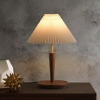A warm pleated-shade table lamp with an elegant tapered base, ideal for bedside tables, living rooms and cosy reading corners.