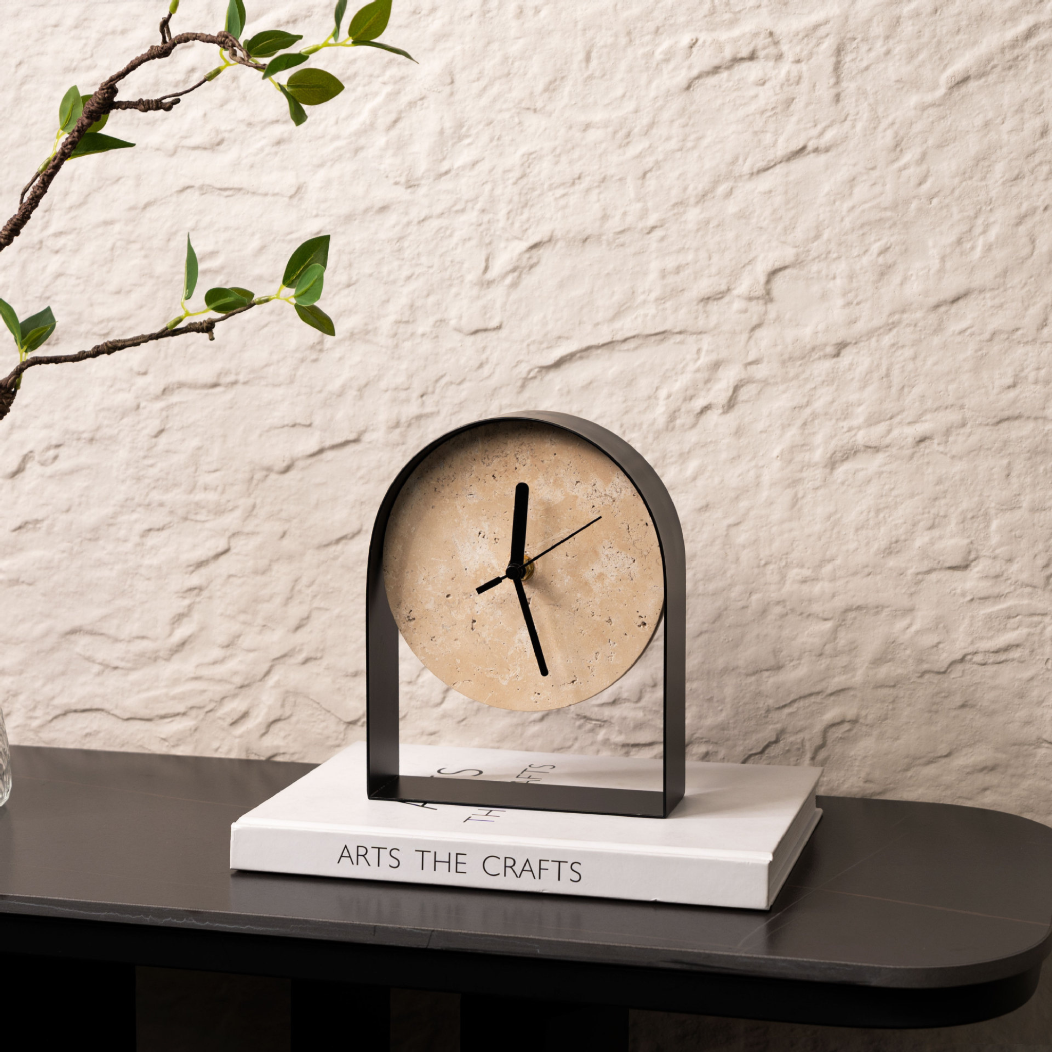 A stone-effect arched table clock with a black frame for UK shelves, desks, bedside tables, mantelpieces and warm minimalist home décor.