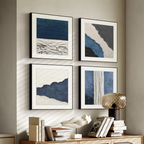 Four blue and neutral textured abstract framed wall art prints arranged above a wooden console table in a warm contemporary interior by KaShi Living.