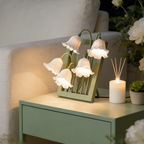 A white floral table lamp with bell-shaped flower shades for UK bedrooms, bedside tables, desks and cosy living room corners.