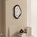 A black and white melted Roman numeral wall clock for UK homes, ideal for adding playful modern character to bedrooms, living rooms, hallways and home offices.