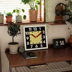 A bold square wall clock with large numbers, red hands and a striped centre design, ideal for kitchens, hallways, home offices and living rooms.