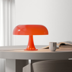 Orange Orla Halo Table Lamp switched off on a dining table beside a mug, open book and stacked books – KaShi Living