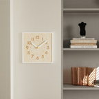 A square light wood-effect wall clock with bold numbers and a white frame, ideal for UK living rooms, kitchens and hallways.