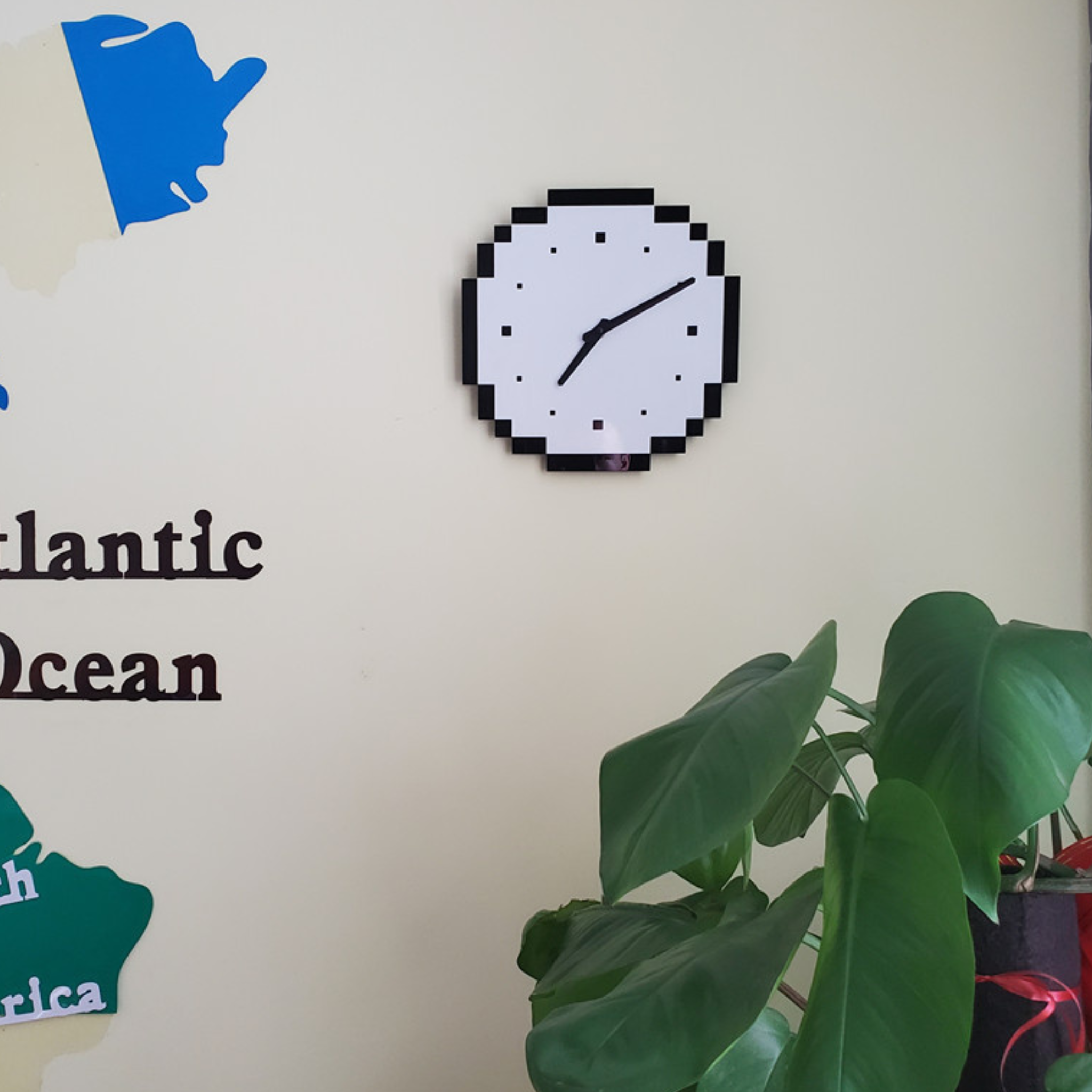 A modern black and white wall clock with a pixel-style edge, ideal for bedrooms, offices, kitchens and living rooms.