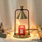 Sienna Antique Gold Cone Candle Warmer Lamp with a brushed gold shade, gold base and black frame, warming a red jar candle.