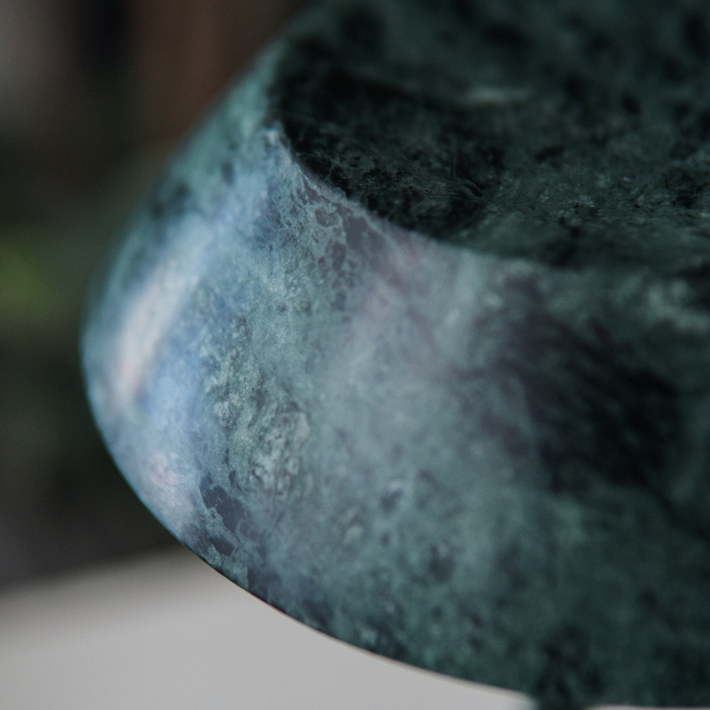 Close-up of a textured dark green stone  portable table lamp
