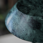 Close-up of a textured dark green stone  portable table lamp