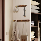 Wall-mounted coat rack with hooks holding a robe, handbag, and other items next to a closet with folded clothes.