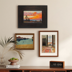 Three framed artworks on a wall above a wooden console table with decorative items in living room, bedroom and hallway