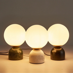 Luna Stone Lamp trio illuminated — glowing frosted globes on marble bases in green, white, and black, ambient night lighting by KaShi Living