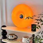 The Marlow Halo Table Lamp is a bold orange circular table lamp for UK bedrooms, shelves, desks and cosy living room corners.