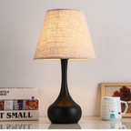 Noir Essence Lamp by KaShi Living — elegant black base table lamp with fabric shade emitting soft ambient light, ideal for bedrooms or studies