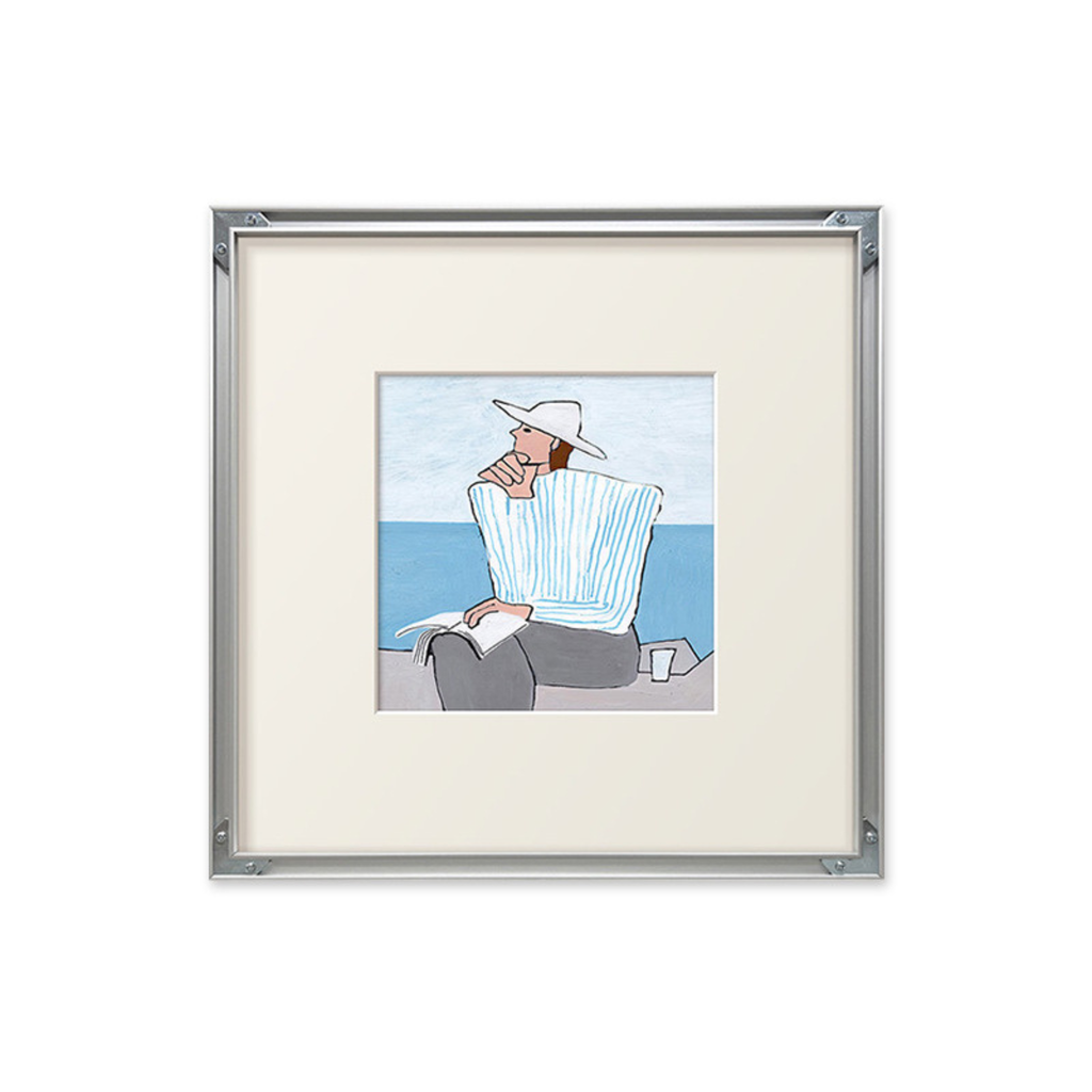 A soft coastal framed wall art piece featuring a seated figure by the sea, suited to UK bedrooms, living rooms and gallery walls.