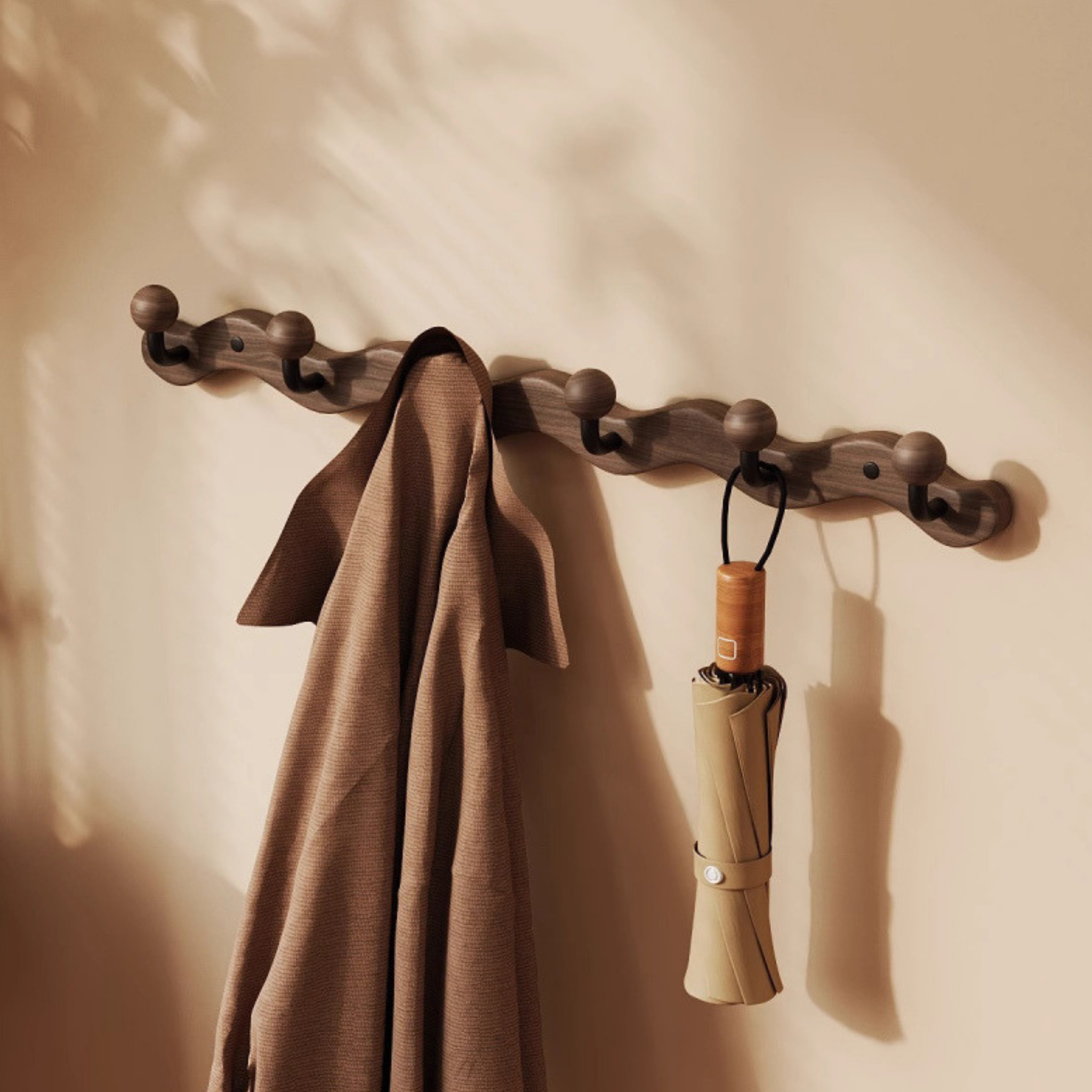 A walnut-tone wavy wall hook rack with four rounded hooks for UK hallways, bedrooms, cloakrooms and small-space coat, bag and key storage.